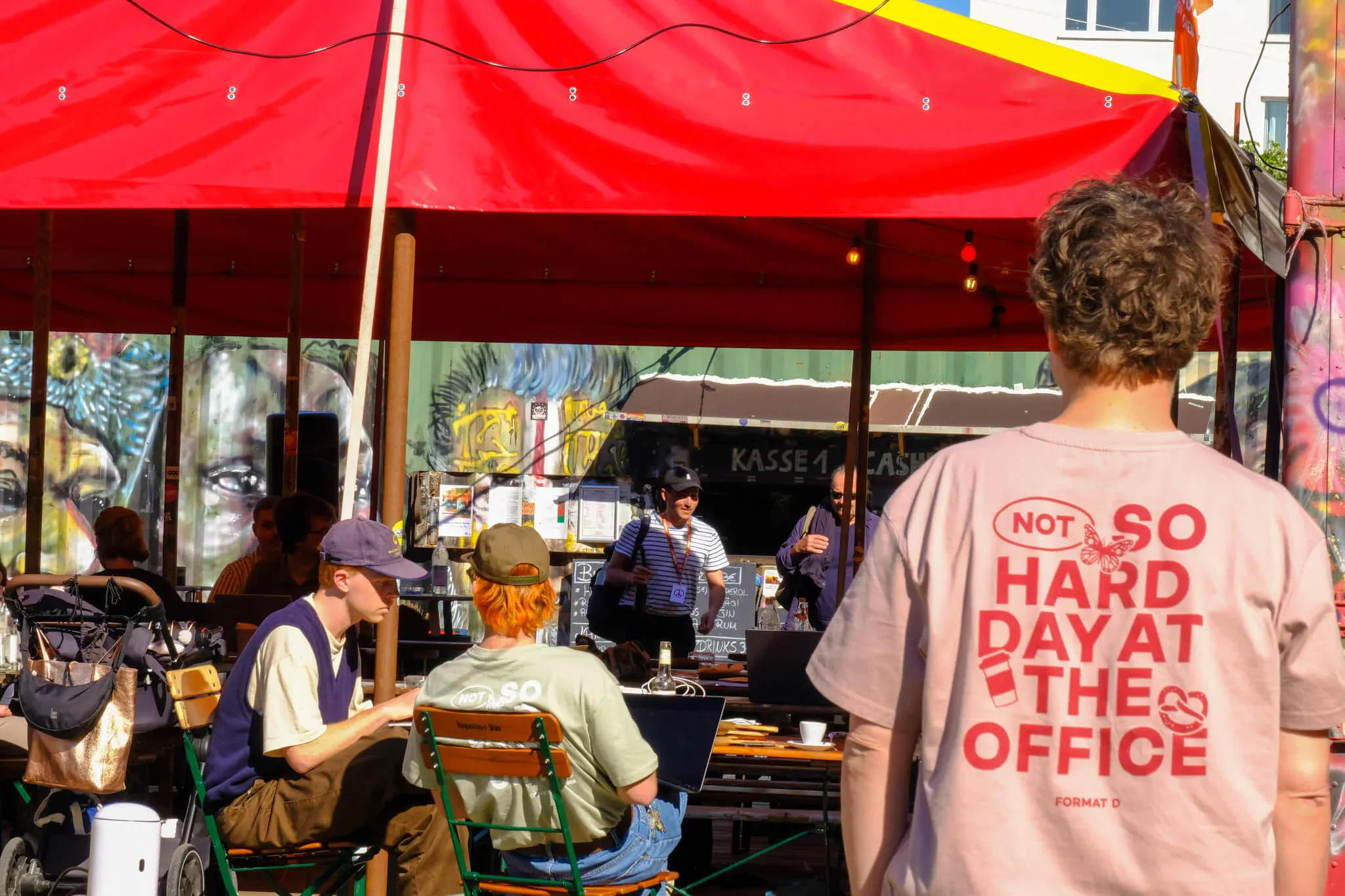 Menschen sitzen in der Sonne und arbeiten gemeinsam an ihren Laptops